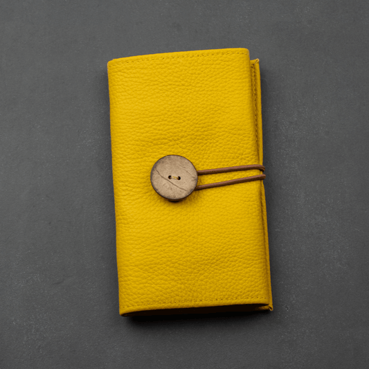 Mustard leather cable organizer packed with cords and chargers