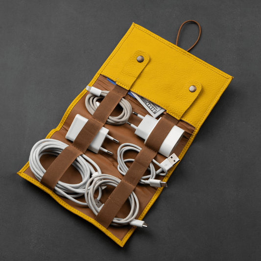 Mustard leather cable organizer packed with cords and chargers
