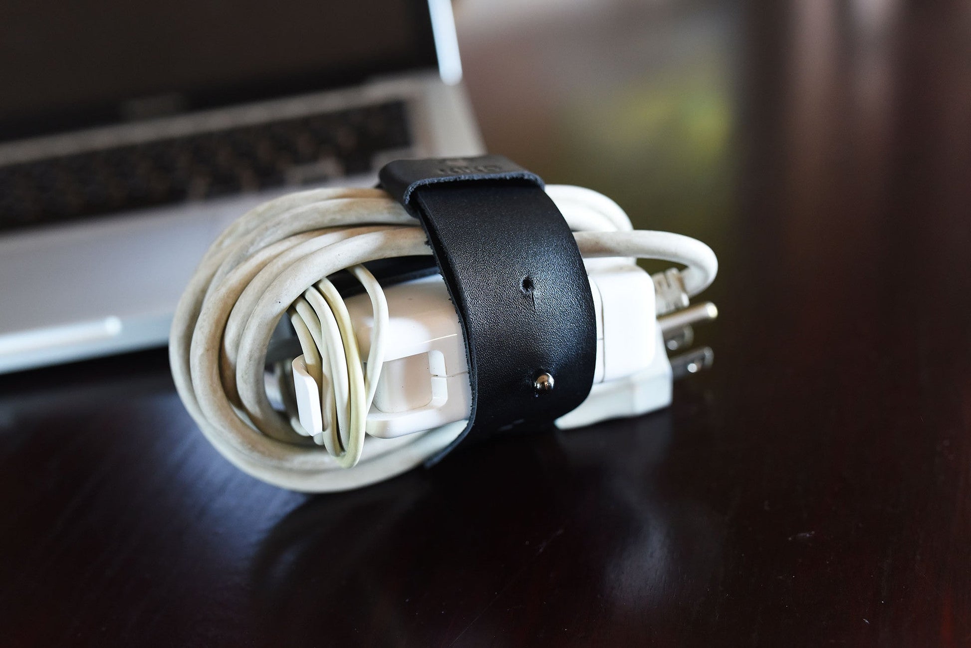 Black leather MacBook cord wrap on desk, Kiko Leather